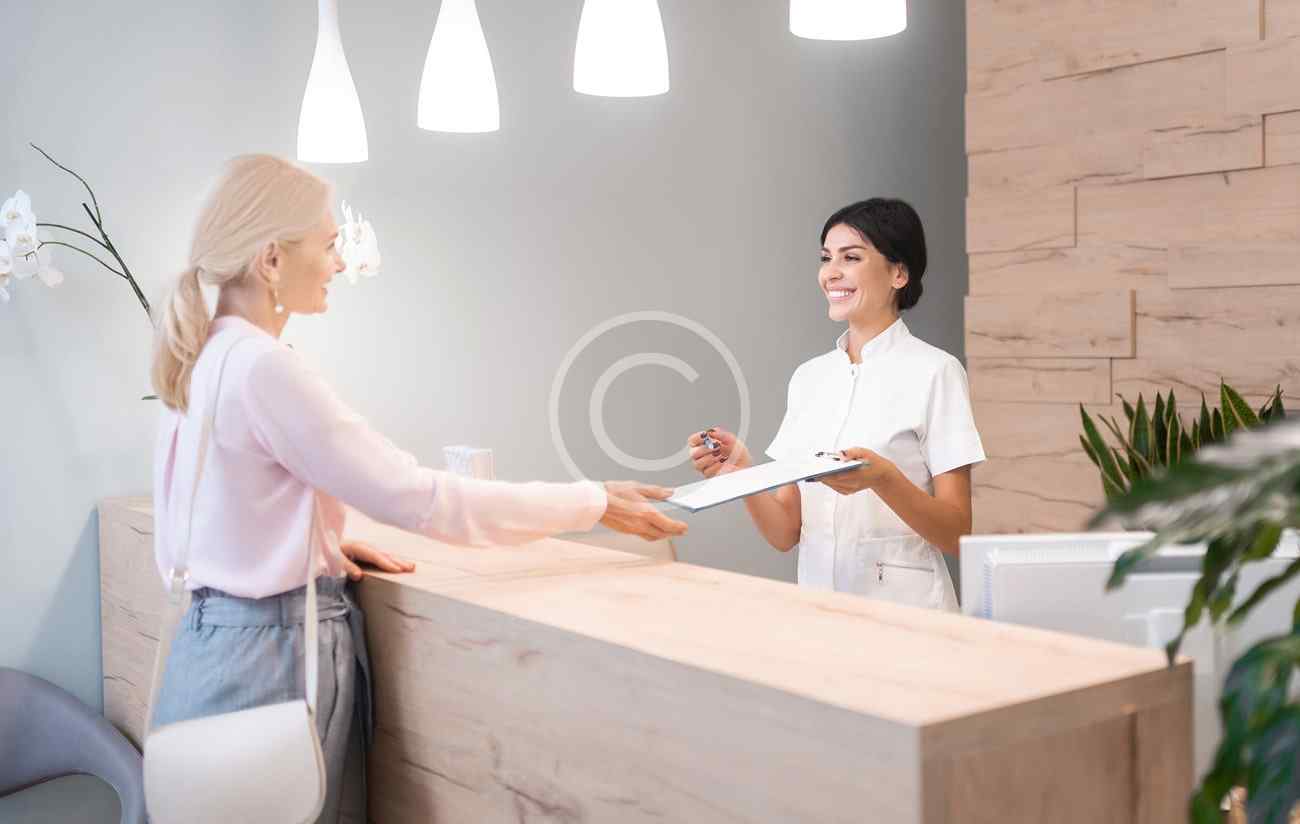 Patientin am Empfang der Praxis
